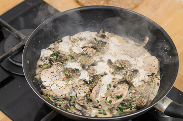 Braised meat in mushroom sauce in a pan