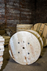 Empty wooden cable spool or bobbin used for winding and storing electrical wire. Industrial storage...