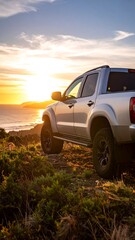 Fototapeta premium Pickup truck at sunset over ocean