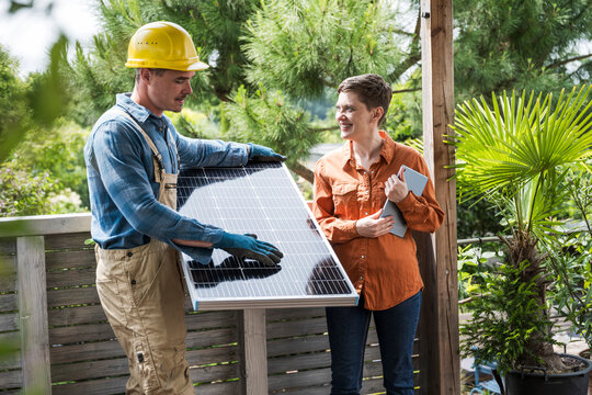 Craftsman giving solar panel installation advice outdoors at home