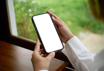 Smartphone mockup blank screen in hand, mobile phone template for app UI and copy space, ideal for digital advertising, website presentation, and ecommerce on wooden table