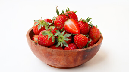 a bunch of ripe strawberries in a wooden bowl on white background
