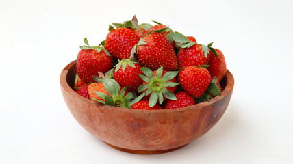 a bunch of ripe strawberries in a wooden bowl on white background