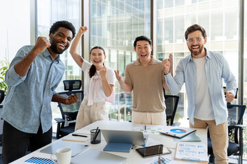 Overjoyed business team celebrating success in modern office