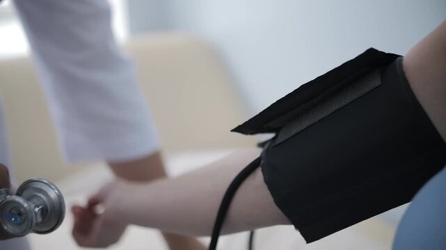 Doctor measuring patient blood pressure with cuff