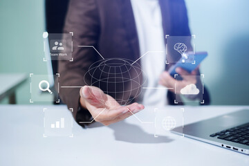 Businessman using mobile with virtual AI, cloud, data, and teamwork icons—illustrating digital transformation, global tech, and innovation in workplace.