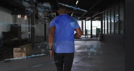 Male runner leaning forward sprinting through industrial hall, graph overlays tracking fitness data - Powered by Adobe
