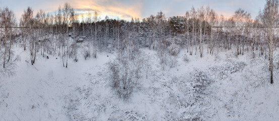 Aerial view of a winter pine forest. Top view of snow-covered pine trees. Beautiful winter forest landscape.