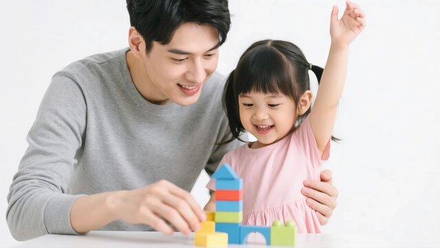 A happy Asian father and his smiling young daughter playing with colorful building blocks together, creating a beautiful and joyful family moment.