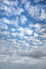 Cirrucumulus clouds create a gentle rhythmic pattern against a blue sky—a natural pattern suitable for use in printed materials, posters, and wallpapers.