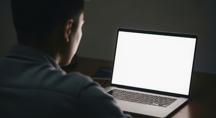 Person in dark room looking at illuminated laptop screen with blank white display woman