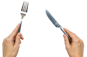 Fototapeta premium two hands holding a silver knife and a fork ready to eat