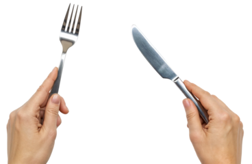 two hands holding a silver knife and a fork ready to eat
