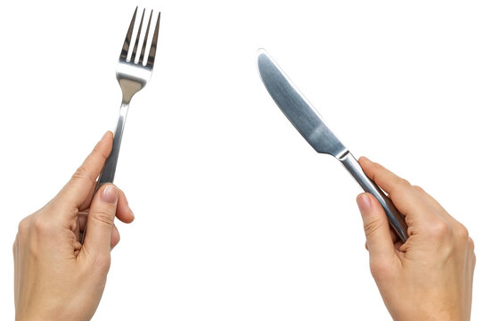 two hands holding a silver knife and a fork ready to eat