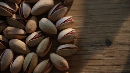 Pistachios on wooden surface with beam of sunlight