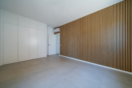 Room with wooden wall texture with wood acoustic panels pattern and closet and cabinets
