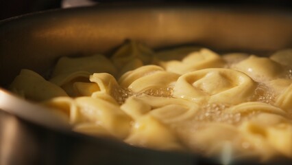 Side view of tortelloni boiling in saucepan with bubbling water