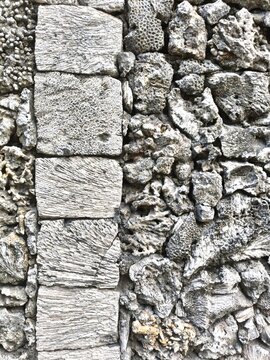 Detail of an external wall made of cut coral blocks and random weathered coral chunks