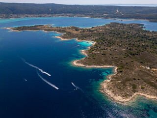 Aerial view of a scenic Mediterranean peninsula with turquoise water, boats, and small beaches. Beautiful summer seascape ideal for travel, tourism, and nature-related projects