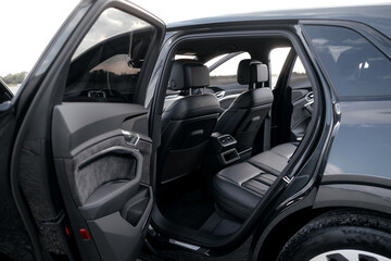 Interior of a premium electric SUV, black leather, aluminum, decorative elements.