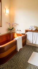 Wooden bathtub with stone floor and orchids.
