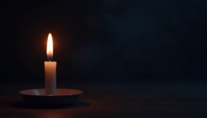 Single candle flame illuminates dark background, calm, mystery
