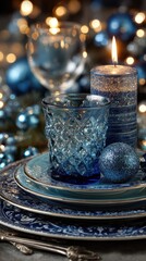 Elegant blue holiday table setting with candles, glassware, and ornaments for a festive celebration at night