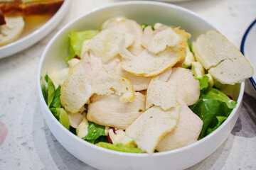 Delicious chicken salad served in a bowl with fresh greens and croutons