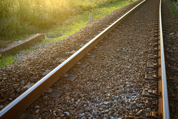 Naklejka premium The Sun Setting on a Railway Line in Summer. Concept The end of a beautiful day.