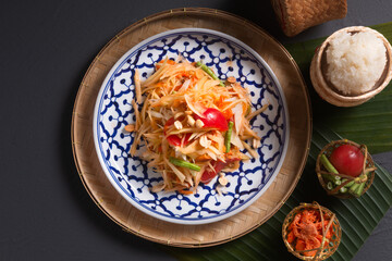 Food concept Thai authentic Som Tum Thai Thai Green Papaya Salad on dark black background with copy space