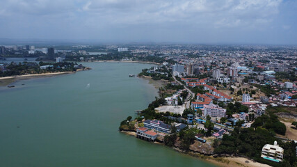 Fototapeta premium Expansive aerial view captures the vibrant cityscape along the coastline, showcasing urban development near tranquil waters.