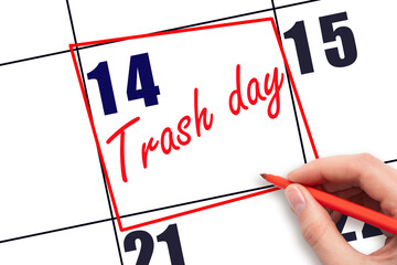 14th day of the month.  Hand writing Trash day reminder and drawing red frame on calendar with red pen on white background. Concept of scheduling waste disposal.  Planning and scheduling