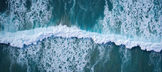 Powerful turquoise wave crests and foams, viewed from above