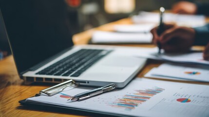 The laptop and documents illustrating business analysis and strategy planning.