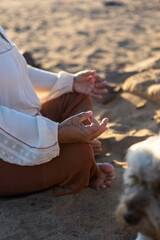 Woman meditating on the beach at sunset during spiritual retreat