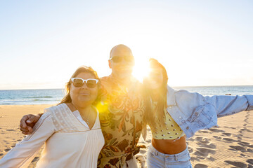 Fototapeta premium Happy tourists embracing on the beach at sunset after spiritual retreat