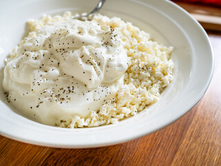 Cottage cheese with yogurt in bowl on wooden table
