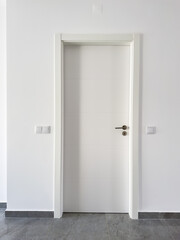 Sleek white door set in a contemporary room with gray tiled flooring and clean walls.