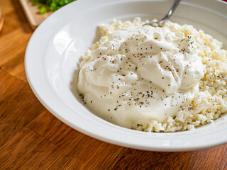 Cottage cheese with yogurt in bowl on wooden table