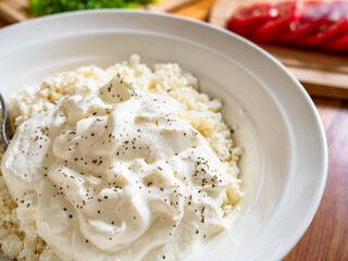 Cottage cheese with yogurt in bowl on wooden table