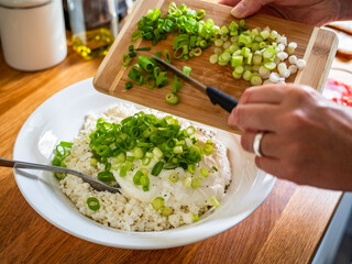 Preparing cottage cheese with yogurt and chives, close-up