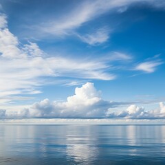 Calm expanse of ocean reflecting a vast, cloud-filled sky.