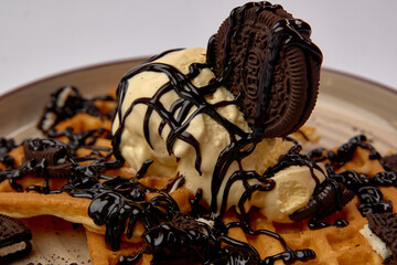 Deliciously Indulgent Waffle Dessert Topped with Creamy Ice Cream, Rich Chocolate Sauce, and...