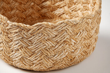 Photorealistic close-up of a woven jute basket with intricate chevron patterns