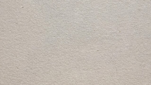 closeup of rough handmade beige mulberry paper texture with natural fiber flecks ideal for stationery or vintage background design