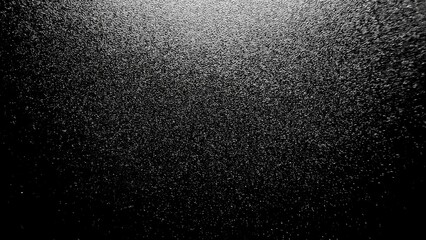 shimmering black surface with reflective metallic texture under dramatic lighting for abstract...