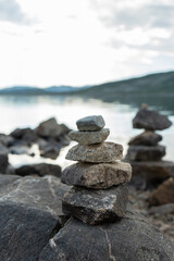 Stone cairns in the wind in Norway near a lake.