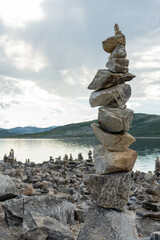 Stone cairns in the wind in Norway near a lake.