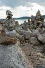 Stone cairns in the wind in Norway near a lake.