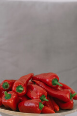 Fresh red chili peppers arranged on a plate with a neutral background
